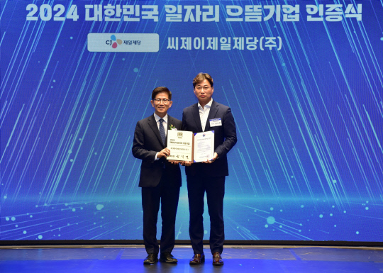 김치홍(오른쪽) CJ제일제당 노사협력담당 상무와 김문수(왼쪽) 고용노동부 장관이 일자리 으뜸기업 인증식에서 기념 촬영을 하고있다. CJ제일제당 제공